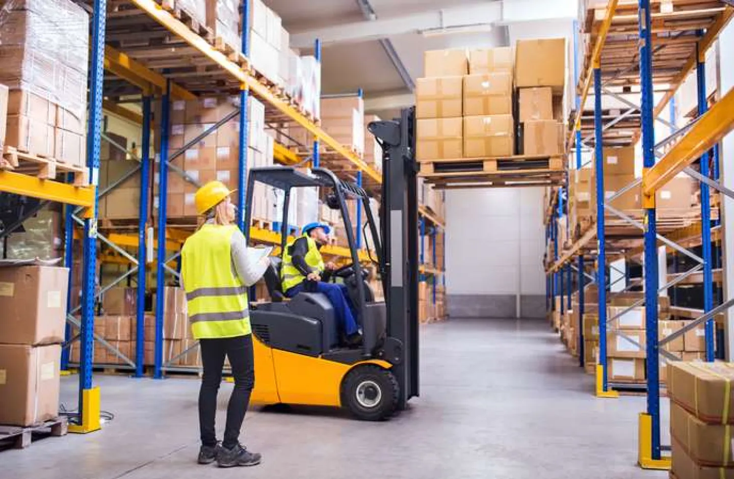 An image of a well-ventilated warehouse with warehouse workers.