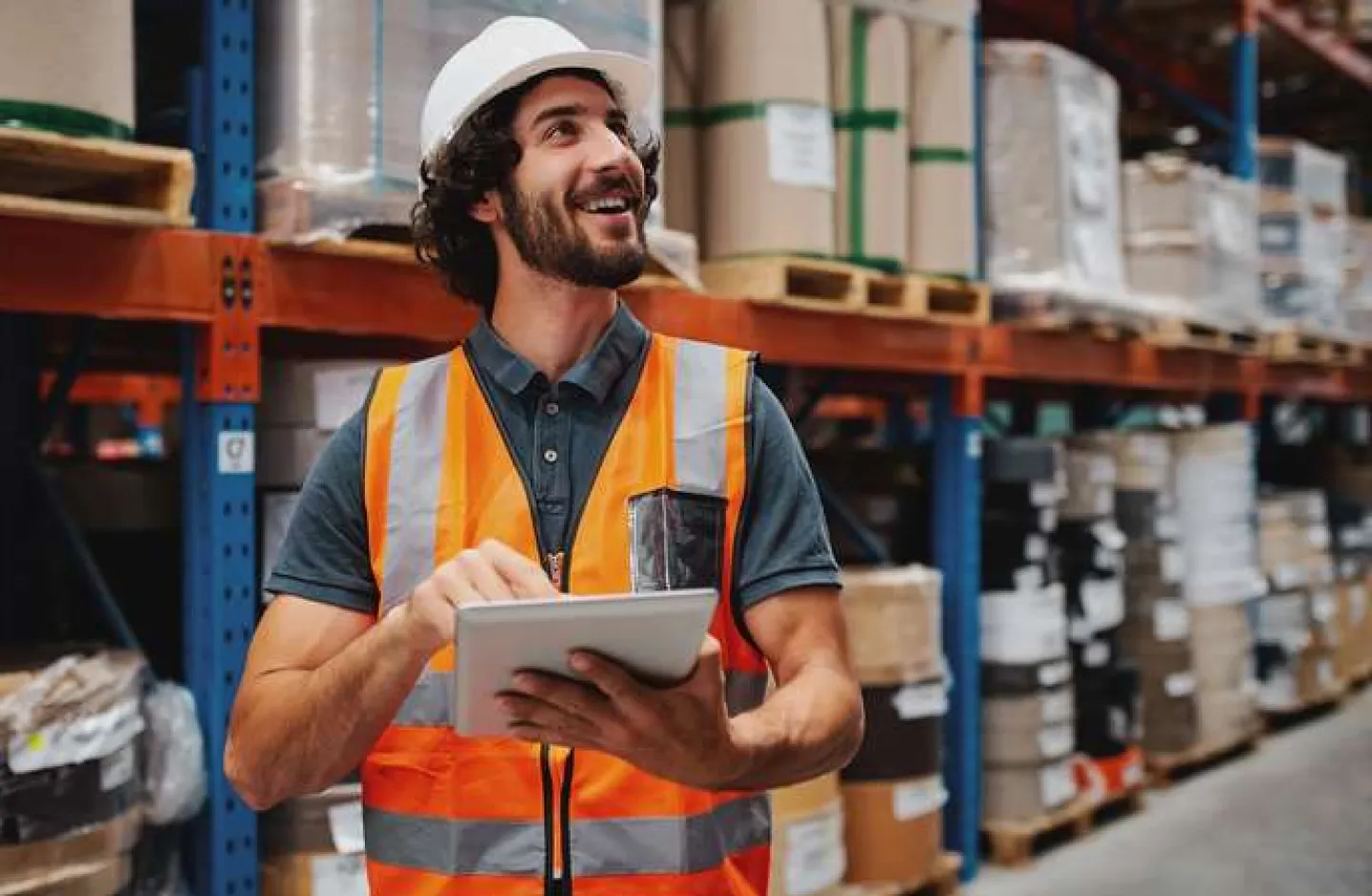 Warehouse Task Management - A warehouse working smiling while working.