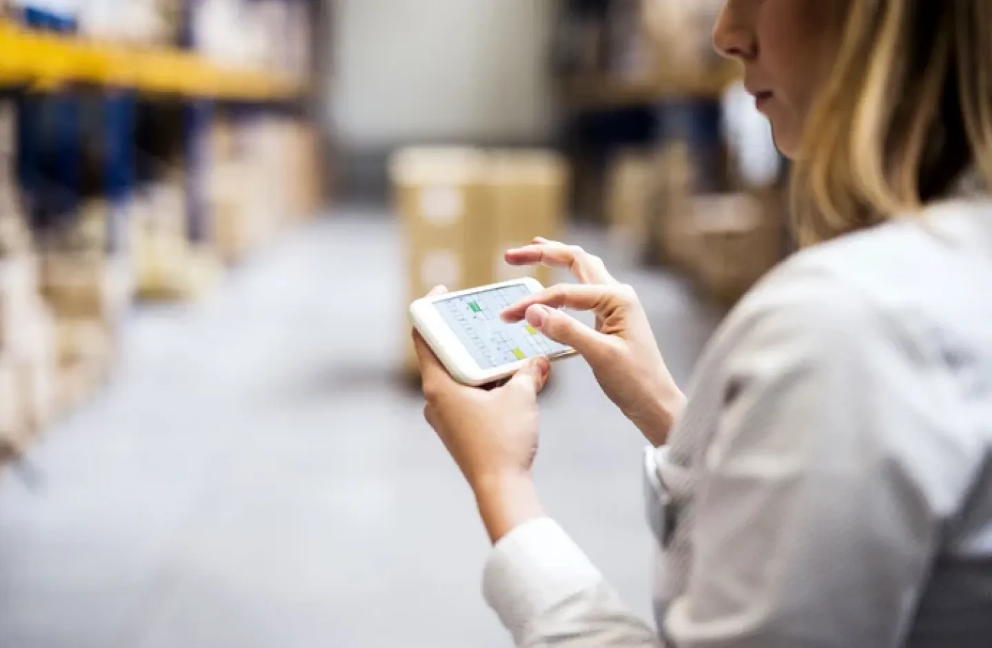 A warehouse manager managing using a smart phone.