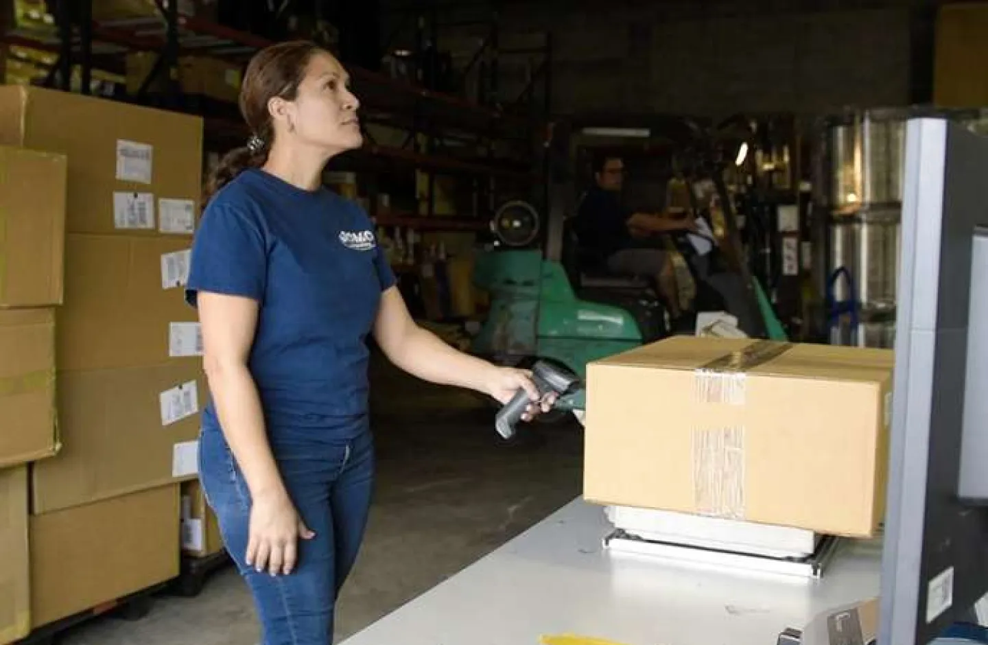 A warehouse worker scanning a parcel with a dimensioner.